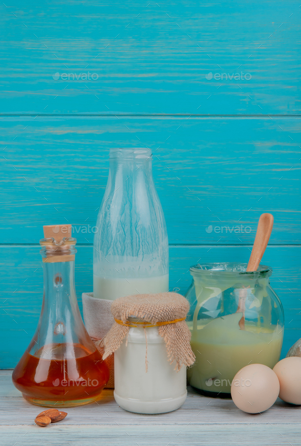side view of milk products as milk, condensed milk, cream with almonds